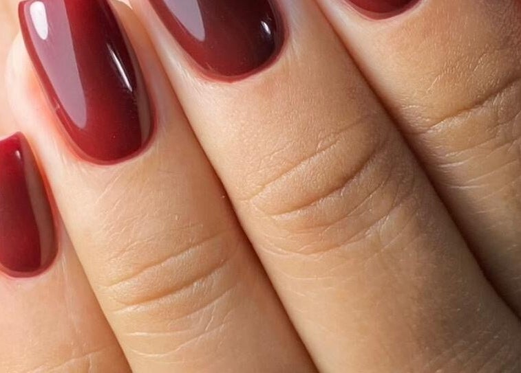 Uñas rojas brillantes en Afro nails, Ocoee, Florida, US. Manicura perfecta y moderna.