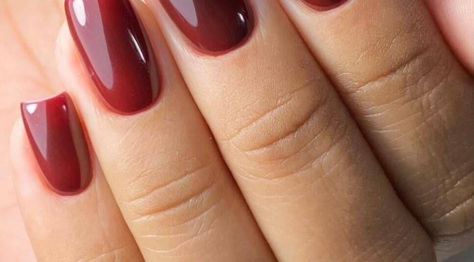 Uñas rojas brillantes en Afro nails, Ocoee, Florida, US. Manicura perfecta y moderna.