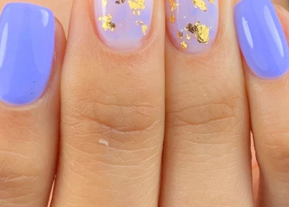 Diseño de uñas con tonos lilas y dorados en Afro nails, Ocoee, Florida, US.