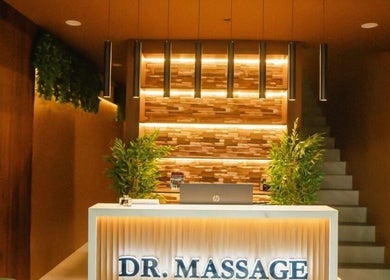 Reception area at Dr. Massage in Taguig, Metro Manila, PH showcasing warm lighting and greenery.