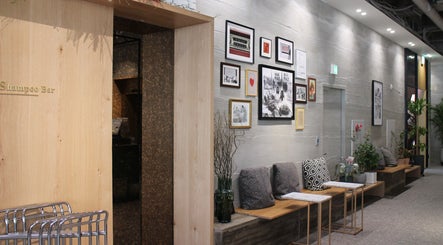 Stylish seating area of Id Hair Gangnam in 서울특별시, 서울특별시, KR with modern decor and wall art.