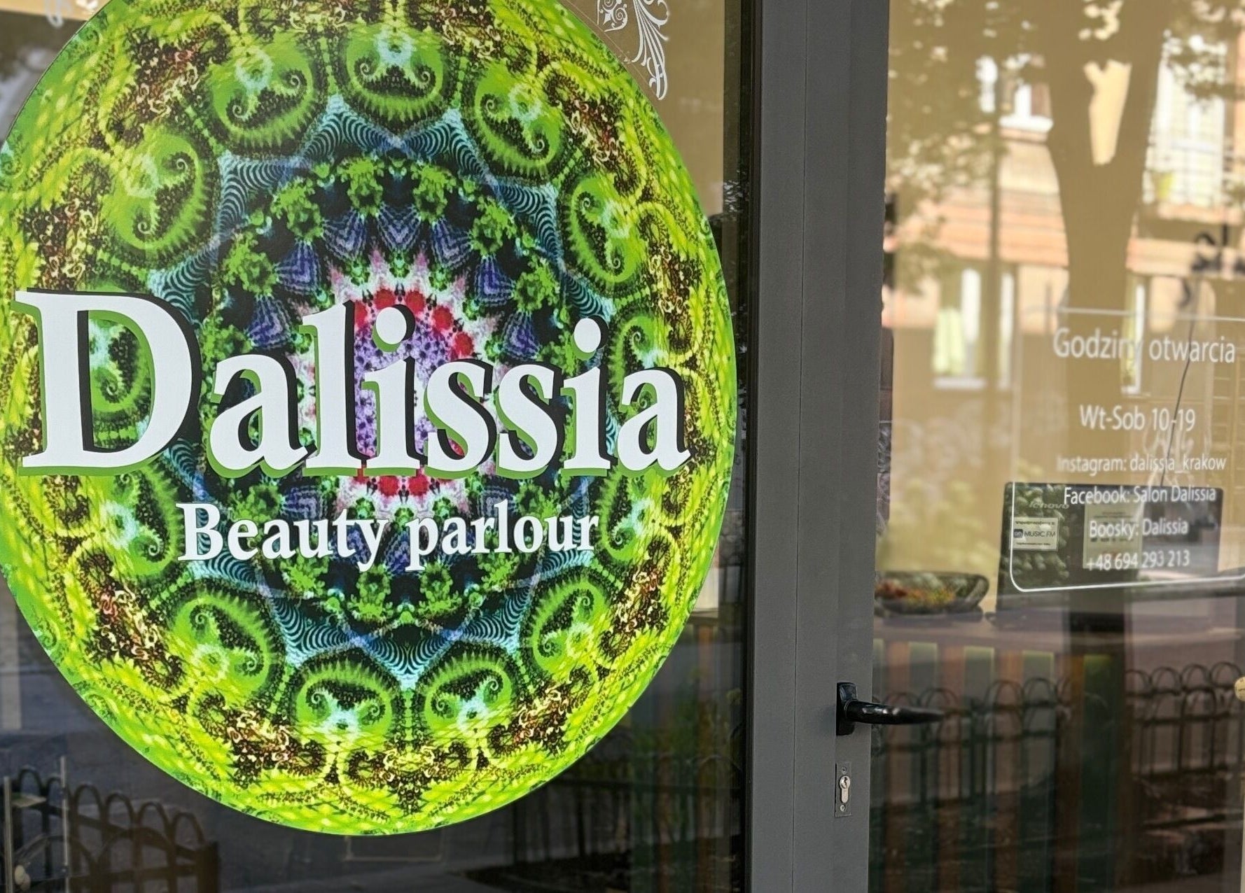 Wejście do Dalissia w Kraków, Województwo Małopolskie z zieloną mandalą na drzwiach.