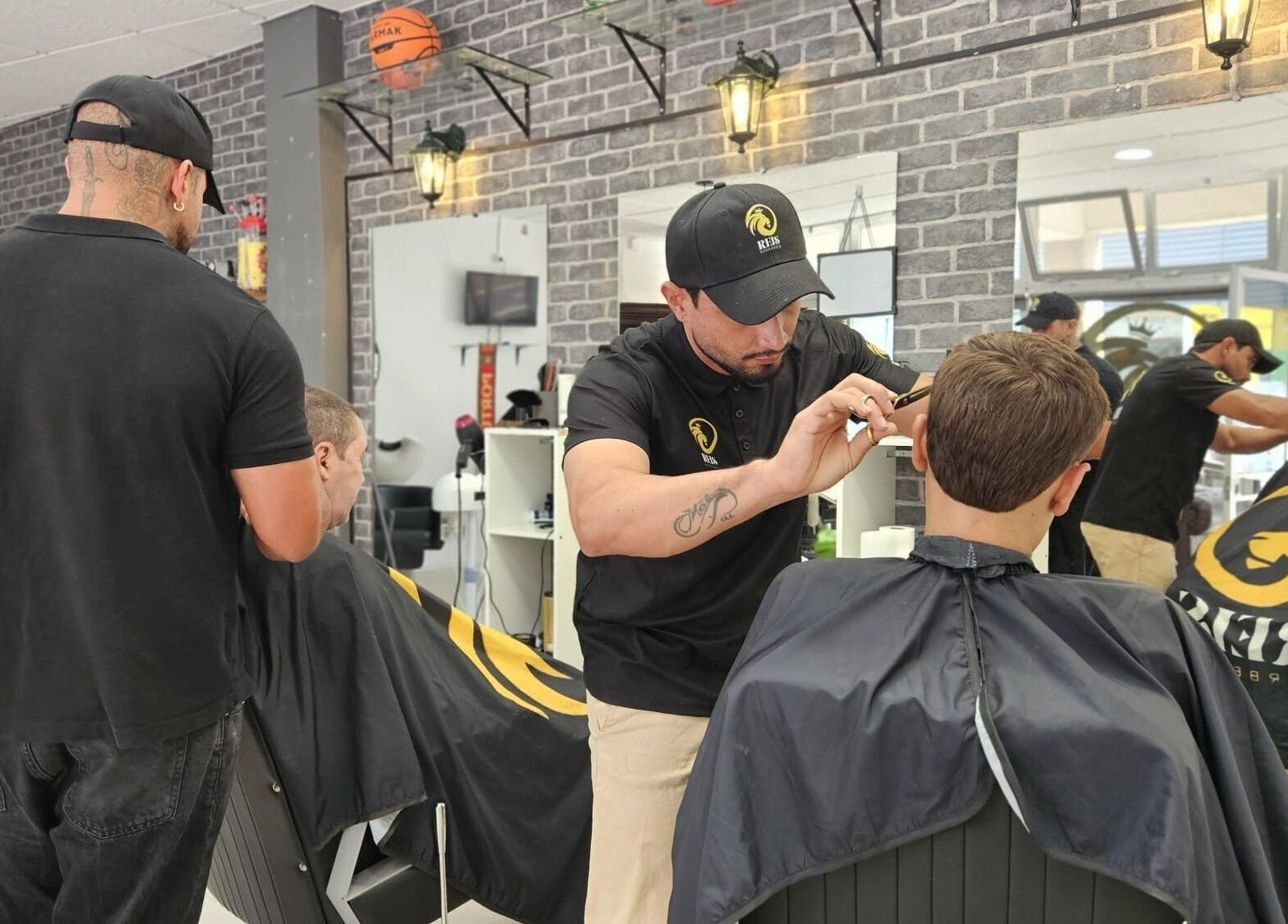 Cabeleireiro em ação na Reis Barbearia em Leiria, Leiria, PT, atendendo cliente com atenção.