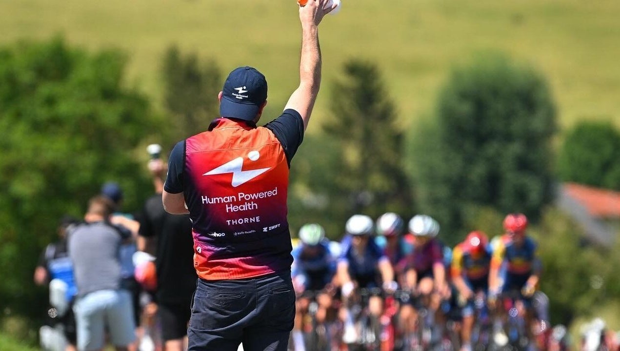 Sportverzorger Wouter bedient wielrenners tijdens een race in Zwevegem, Vlaanderen, BE.