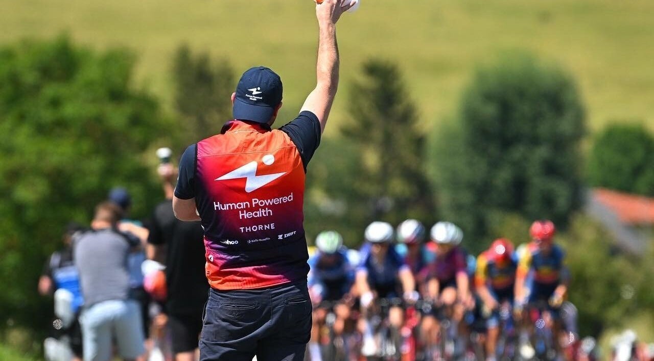 Sportverzorger Wouter bedient wielrenners tijdens een race in Zwevegem, Vlaanderen, BE.