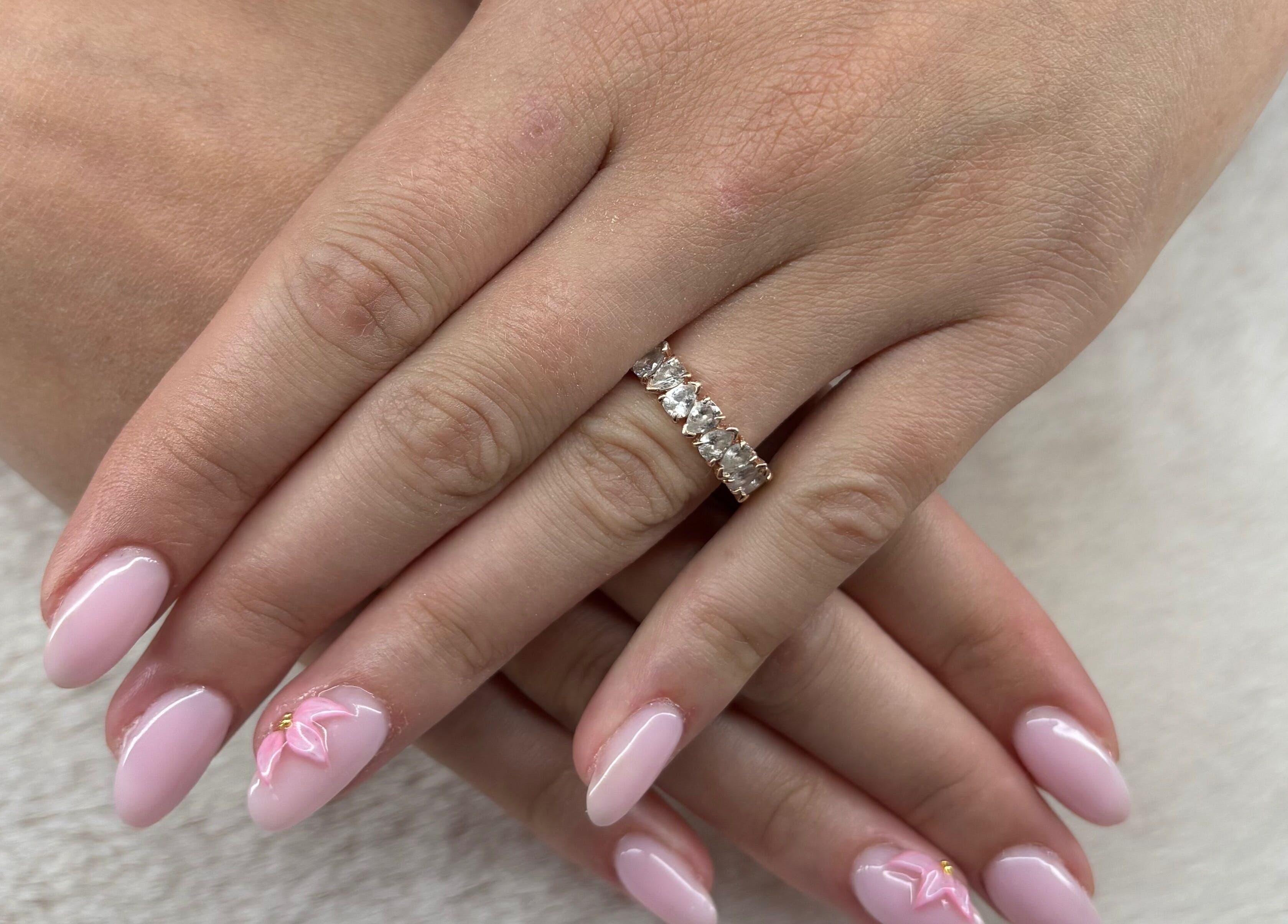 Nail art raffiné à Les Ongles De Lorrie, Palaja, Occitanie, FR. Décor rose délicat avec strass.