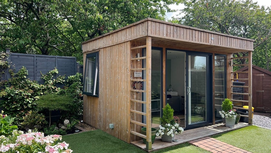 Cozy spa cabin at Young Cosmetics, Luton, England, GB surrounded by lush greenery.