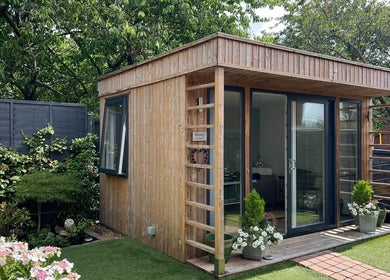 Cozy spa cabin at Young Cosmetics, Luton, England, GB surrounded by lush greenery.
