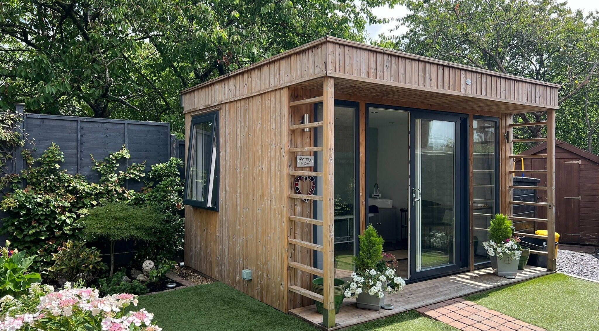 Cozy spa cabin at Young Cosmetics, Luton, England, GB surrounded by lush greenery.