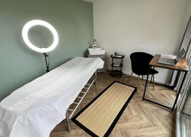 Minimalist treatment room at Young Cosmetics, Luton, England, GB featuring a treatment bed and modern decor.