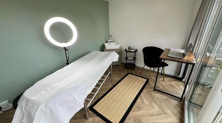 Minimalist treatment room at Young Cosmetics, Luton, England, GB featuring a treatment bed and modern decor.