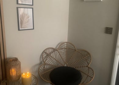 Warm and inviting corner at Repton Revive in Repton, England, GB with candlelight and wicker decor.