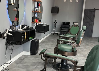 Interieur van Barbershop Tubbergen in Tubbergen, Overijssel, NL, met stijlvolle groene stoelen.