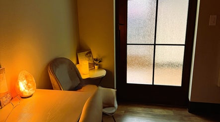 Cozy waiting area at Serenity Aesthetics & Spa, Charlotte, North Carolina, US with soft lighting and a chair.