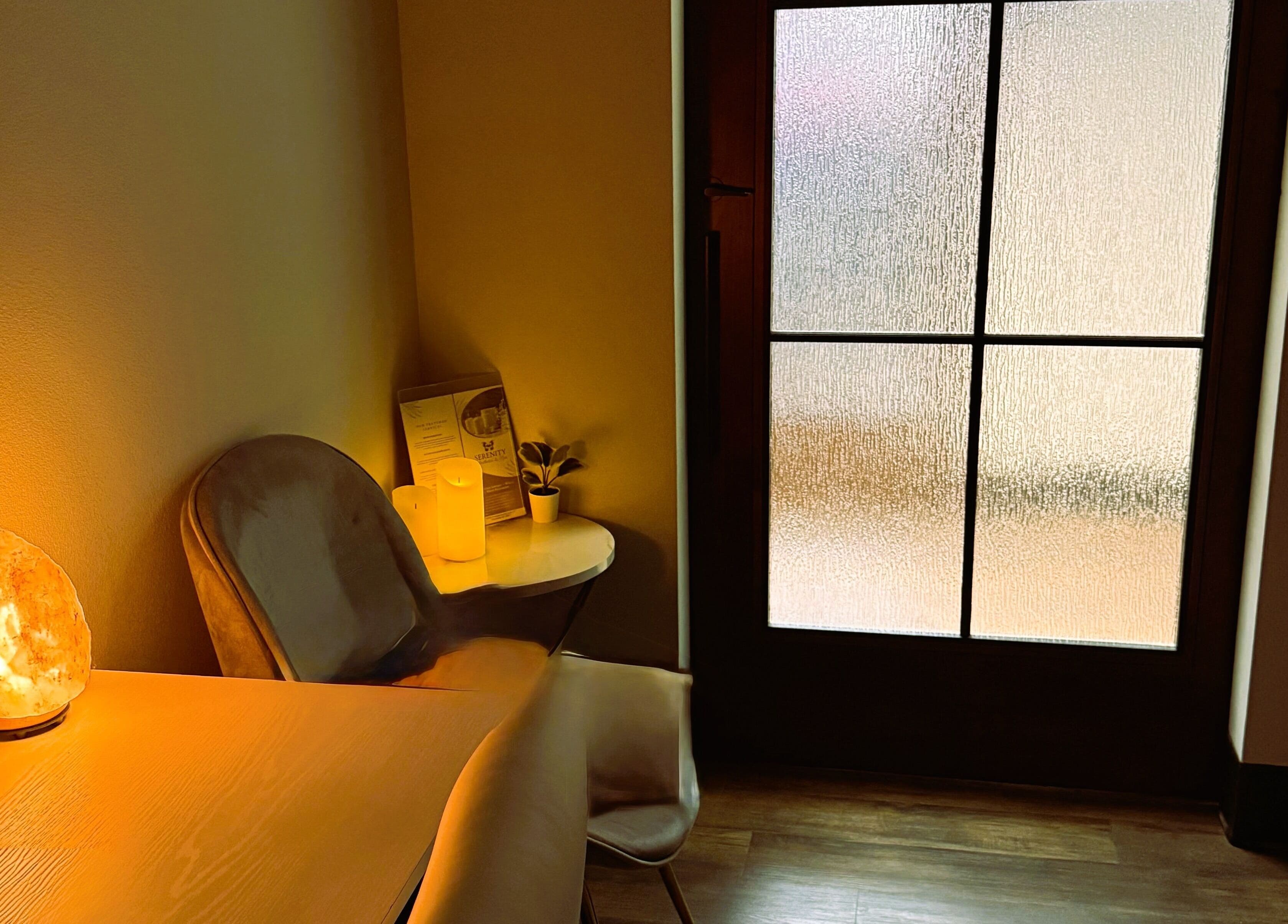 Warm, inviting spa corner at Serenity Aesthetics & Spa in Charlotte, North Carolina, US, with candles and salt lamp.