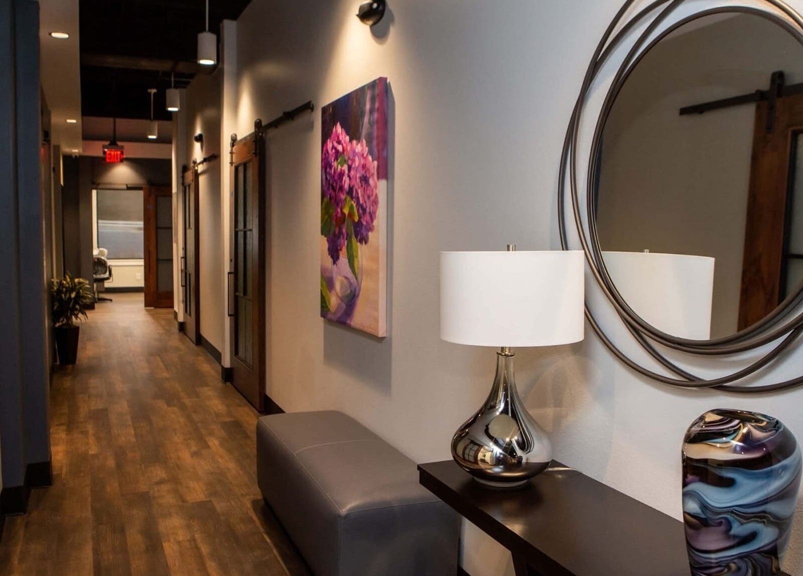 Elegant hallway at Serenity Aesthetics & Spa, Charlotte, North Carolina, US, featuring a mirror and art decor.