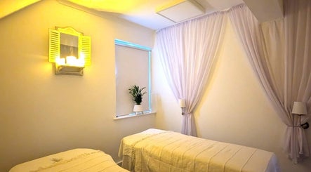 Peaceful massage room at Lanna Thai Massage & Wellness Marlow, featuring two tables and soft lighting. Marlow, England, GB.