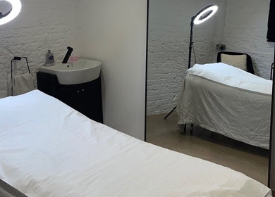Calming treatment room at TINTD Society, Paynes Hall, England, GB featuring massage bed and soft lighting.