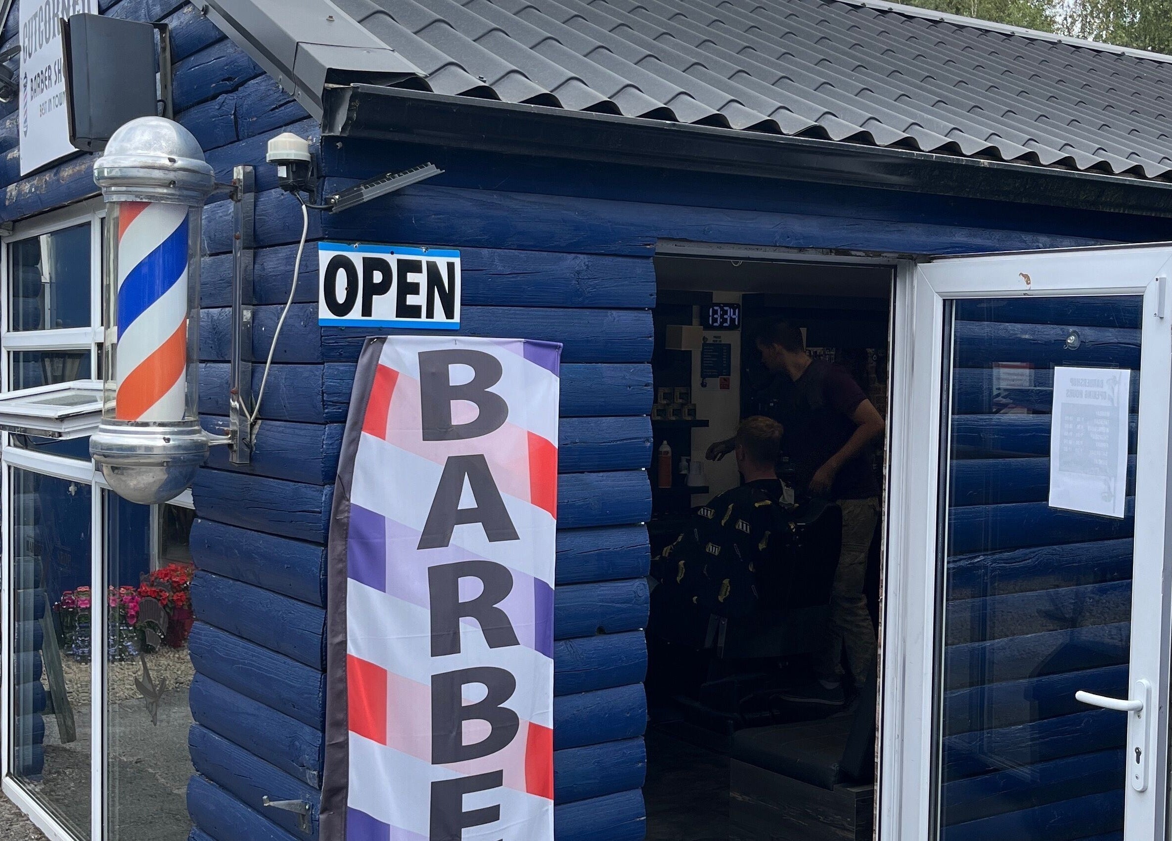 Exterior of Cutcorner barbershop with vibrant blue facade in County Kildare, County Kildare, IE.