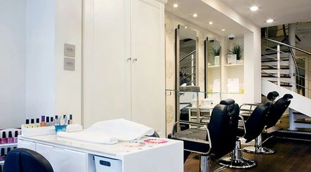 Modern salon interior at Anya Spa@Angel, London, England, GB featuring chic black chairs and a tidy nail station.