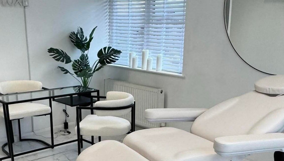 Sculpted By SL's serene treatment room with white furnishings in Ashford, England, GB.