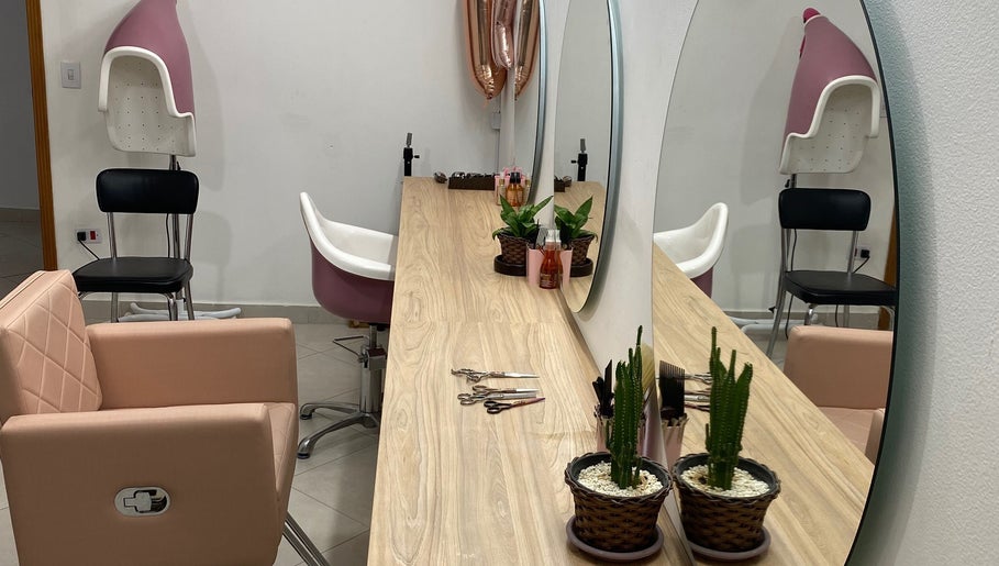 Mesa elegante no Studiocrespa&cacheada em São Paulo, SP, BR, com espelho grande, plantas e poltronas de beleza.