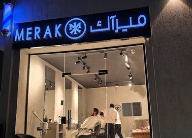 Night view of MERAK BARBERSHOP in Jeddah, Makkah Province, SA, showcasing its bright signage and modern interior.