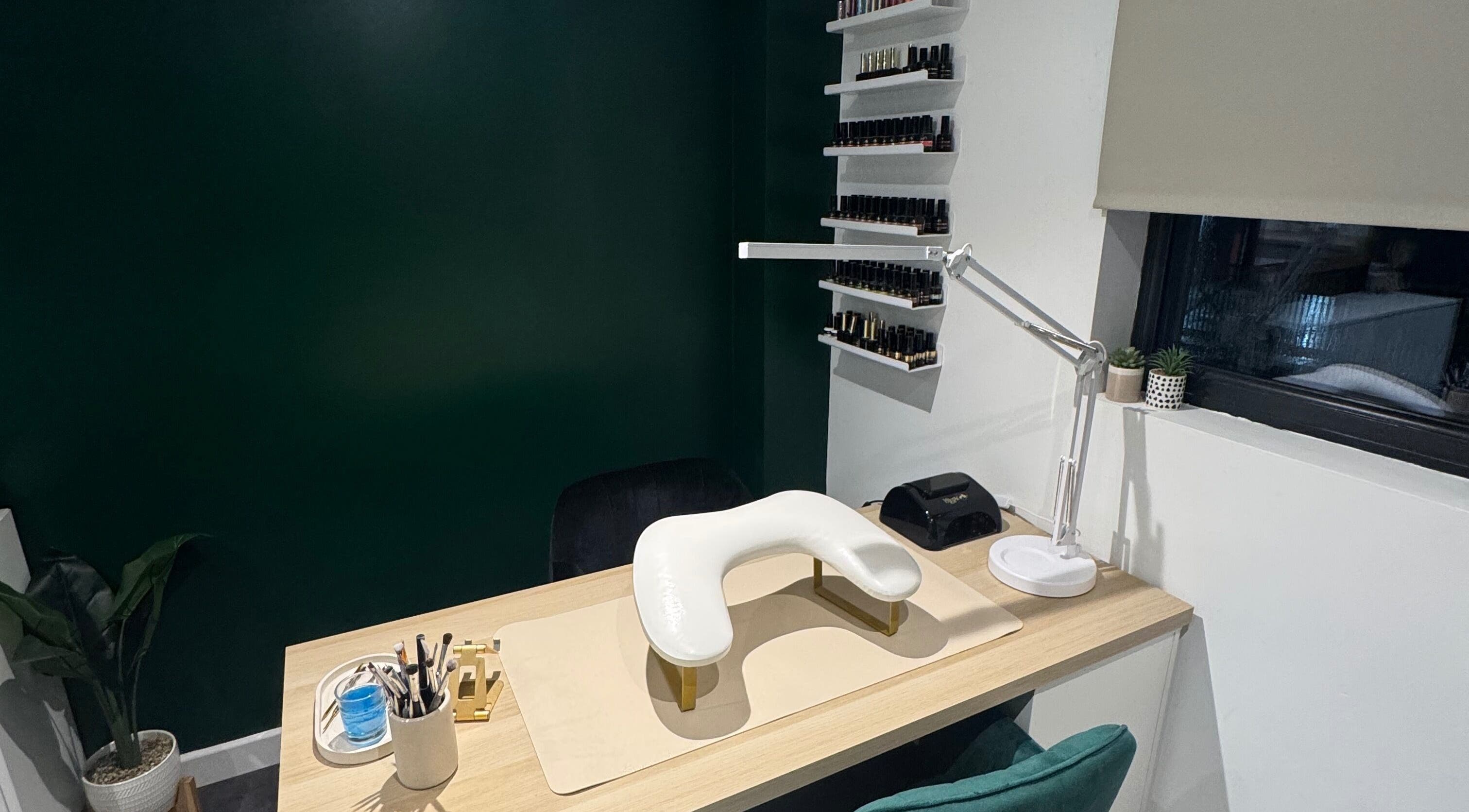 Elegant nail station at SH Enhancements, Somerton, England, GB with organized polish display and modern decor.