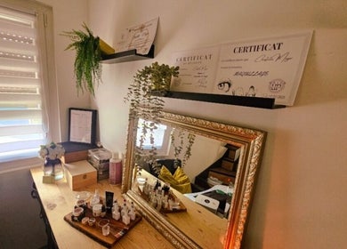 Table de beauté chez Madame BLK, Orny, France, avec un miroir doré et des certificats de beauté.