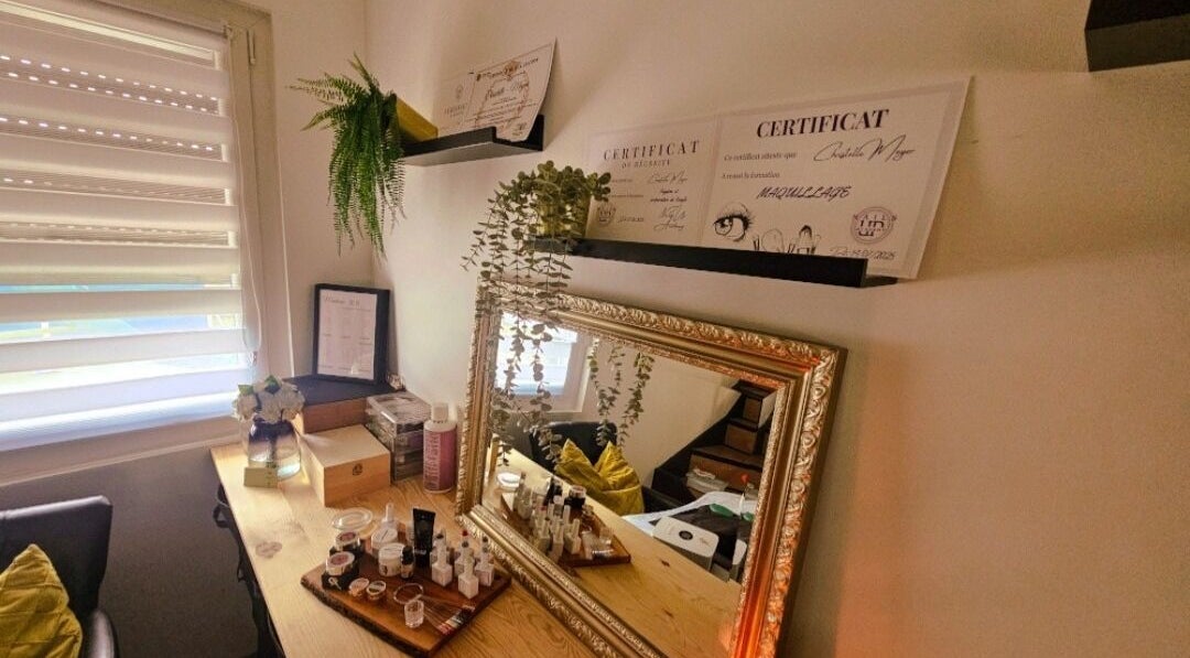 Table de beauté chez Madame BLK, Orny, France, avec un miroir doré et des certificats de beauté.