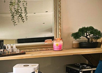 Élégant miroir encadré chez Madame BLK, Orny, France. Décoration zen et produits de beauté visibles.