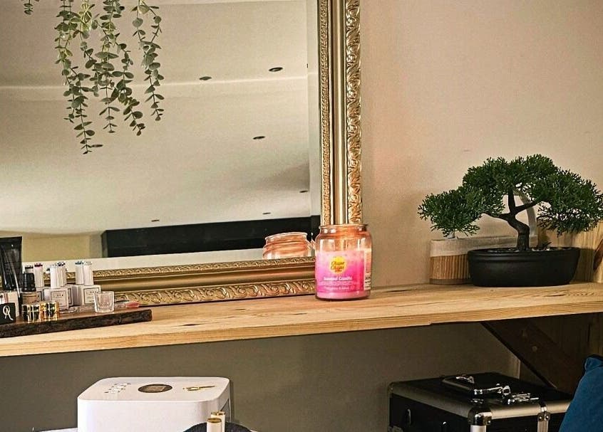 Élégant miroir encadré chez Madame BLK, Orny, France. Décoration zen et produits de beauté visibles.