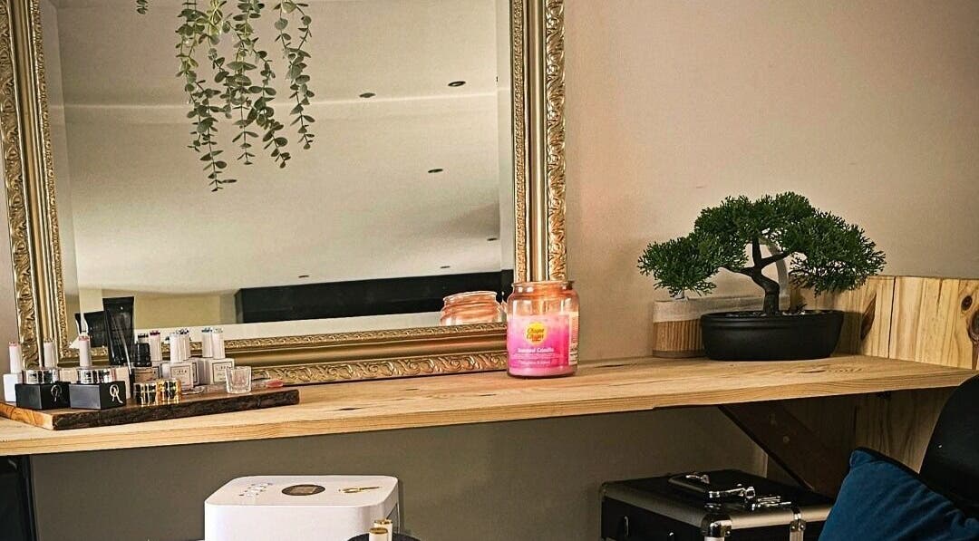 Élégant miroir encadré chez Madame BLK, Orny, France. Décoration zen et produits de beauté visibles.