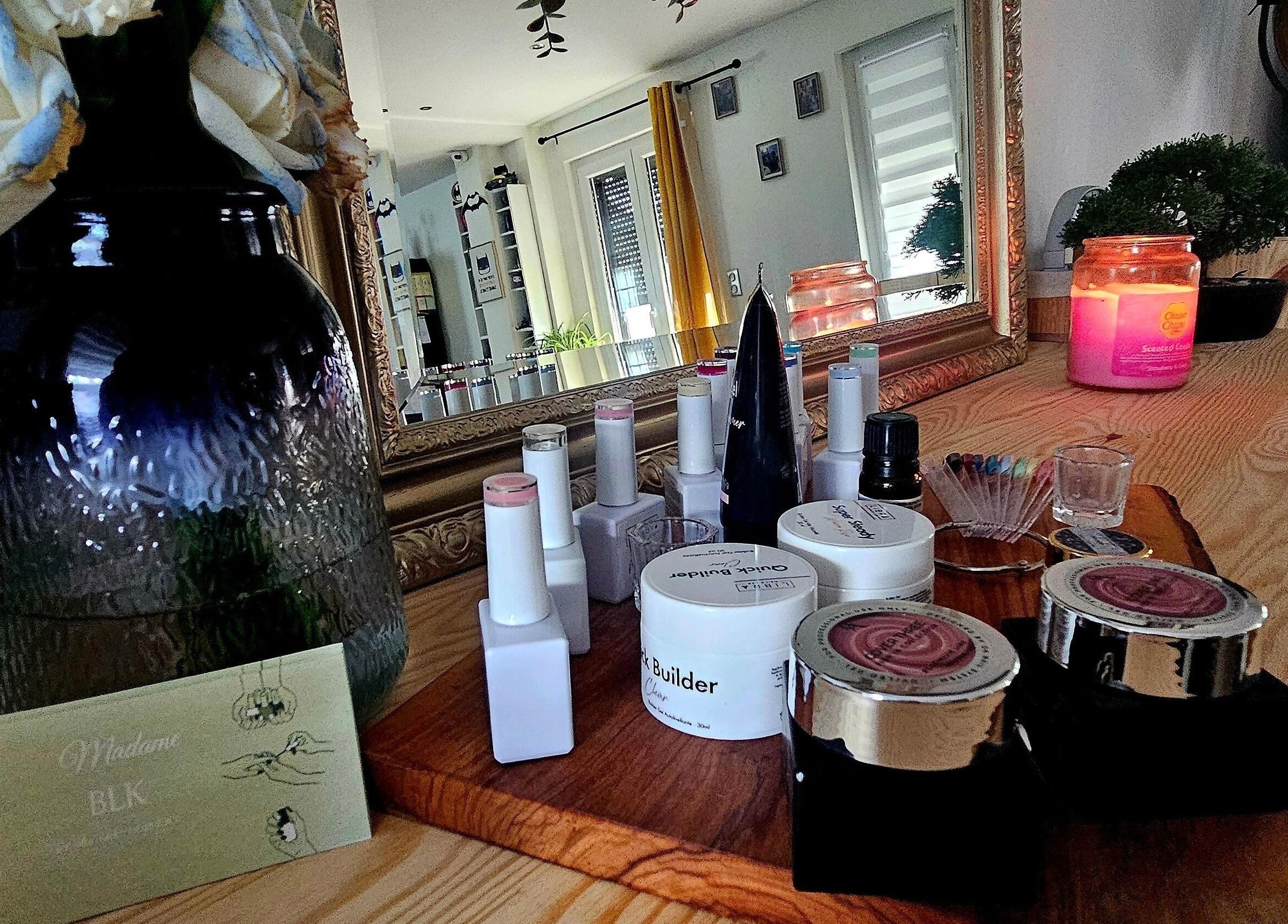 Produits de beauté sur un comptoir chez Madame BLK, Orny, France, FR, avec miroir et bougie parfumée.