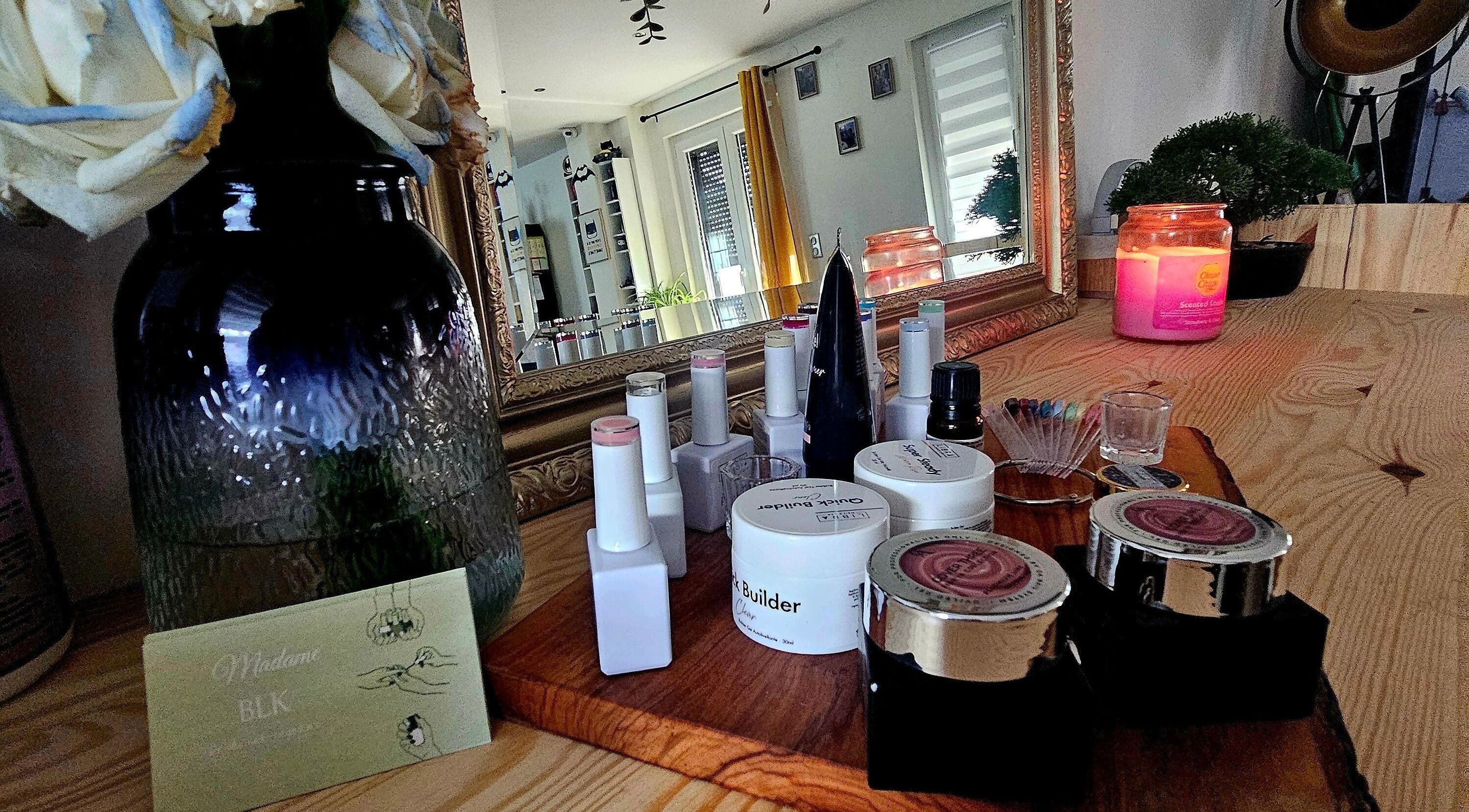 Produits de beauté sur un comptoir chez Madame BLK, Orny, France, FR, avec miroir et bougie parfumée.