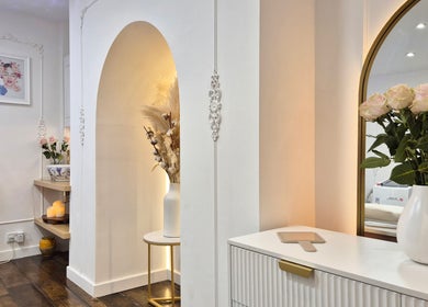 Elegant interior of Skin Well Aesthetics Boutique in London, England, GB featuring floral decor and soft lighting.