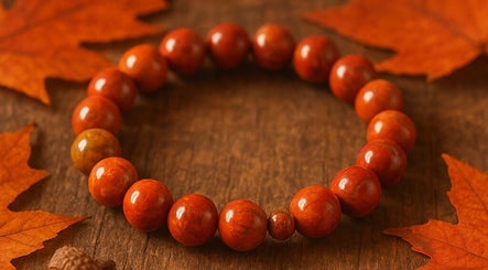 Bracelet en perles orange sur fond automnal à Bien Naître par Ailes, Castelmoron-sur-lot, Nouvelle-aquitaine, FR.