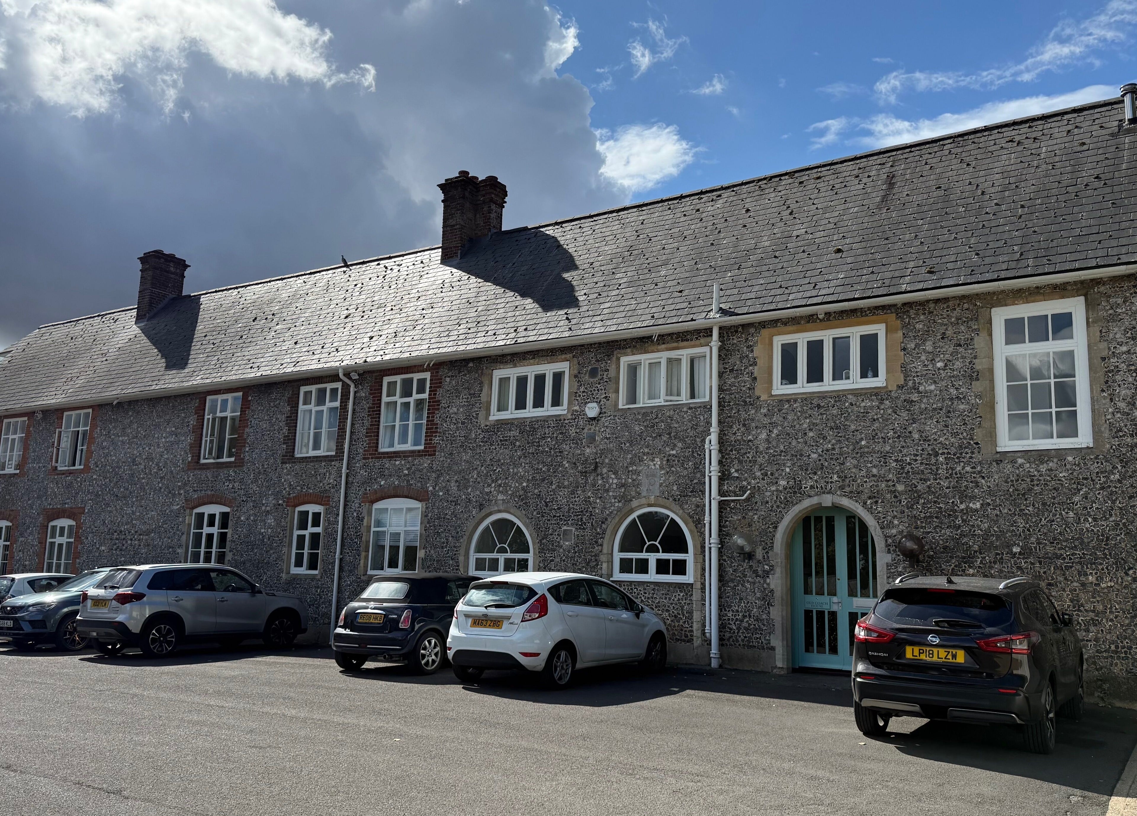 Front view of Chloë Jane Aesthetics' historic building in Farleigh Wallop, England, GB, under a cloudy sky.