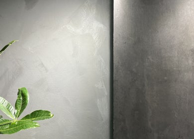 Elegant interior of VOIDE nail studio in Richmond, BC, showcasing a textured gray wall with lush green leaves.