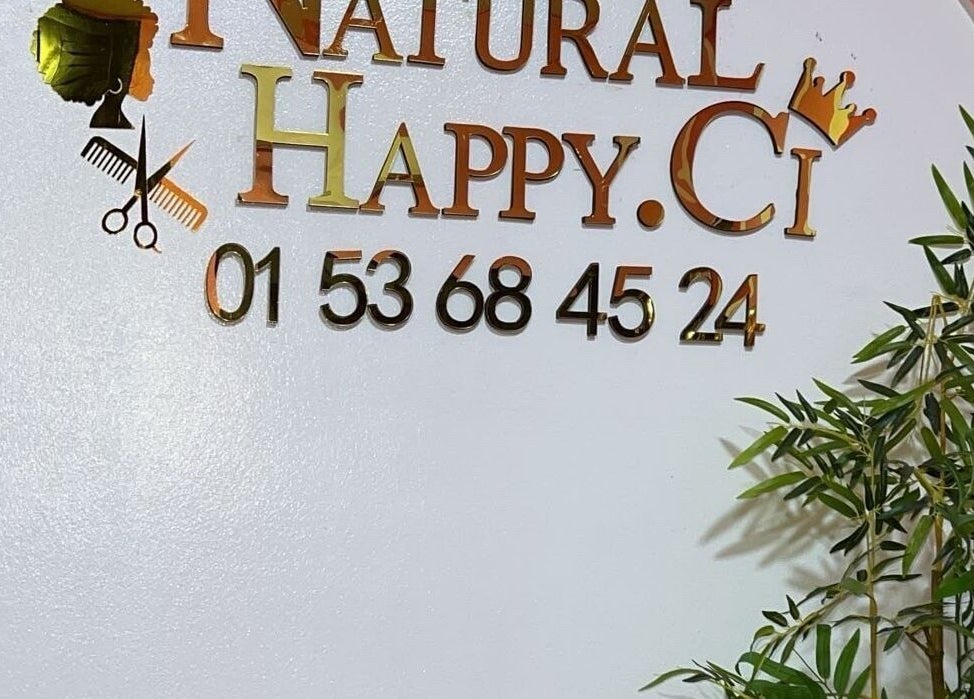 Enseigne dorée de Natural Happy.Ci avec plante, située à Abidjan, District Autonome D'abidjan, CI.