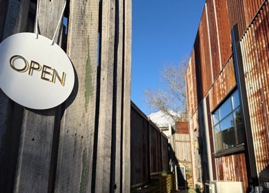 Open sign at Sensalium, Blackheath, New South Wales, AU. Rustic building and clear sky in the background.
