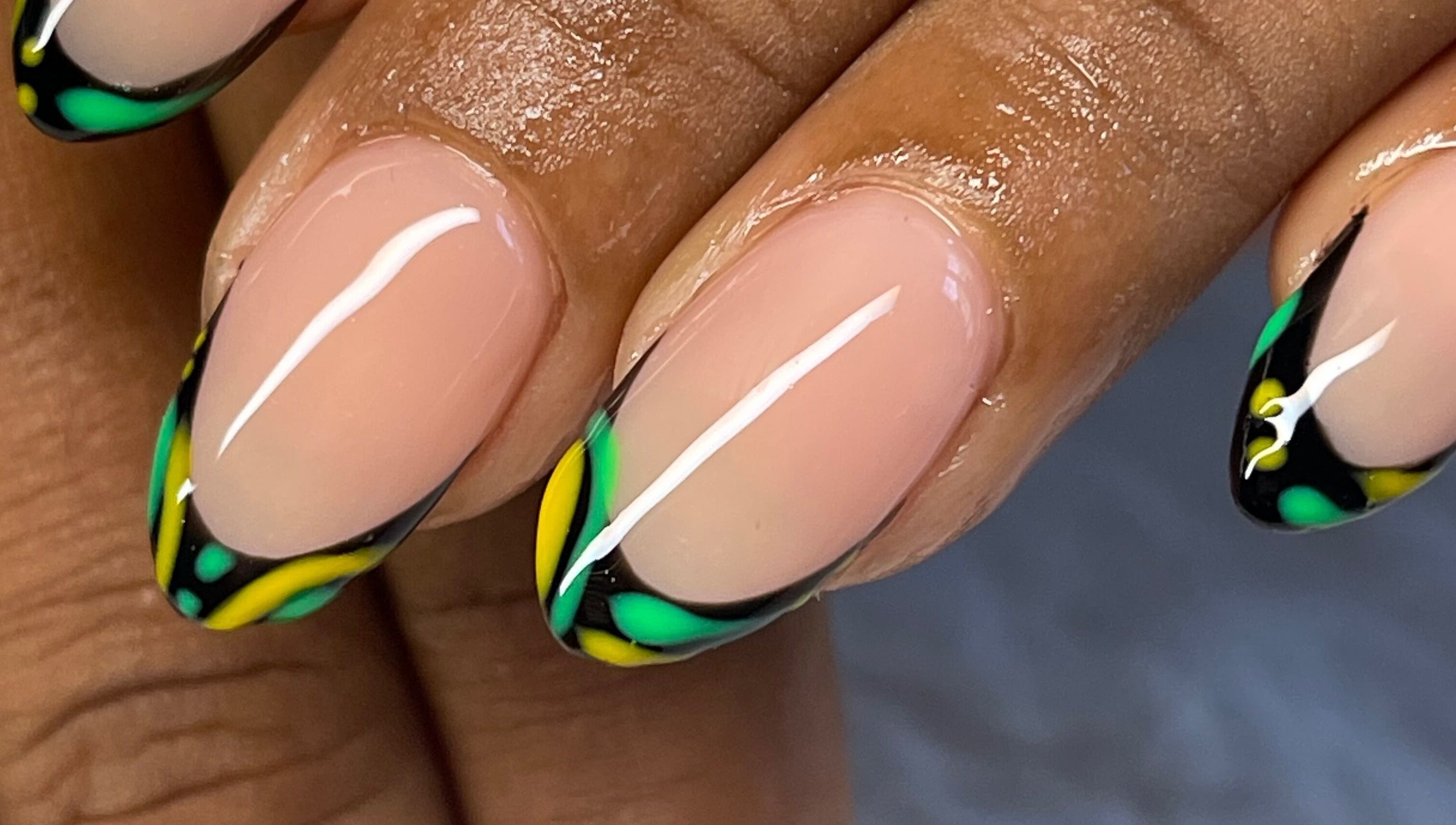 Vibrant green and yellow nail art at Elegant Tips, Ocho Rios, JM, showcasing expert manicure designs.