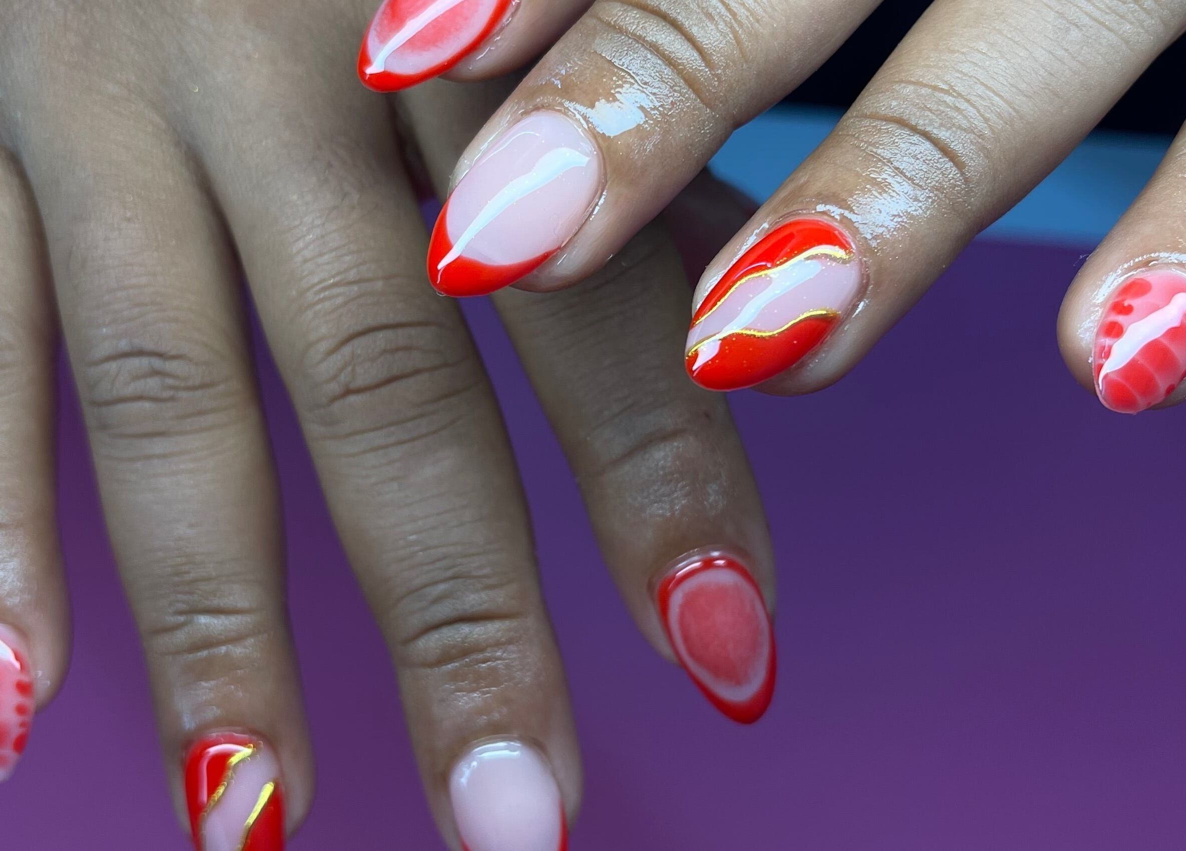Stylish red nail art at Elegant Tips in Ocho Rios, JM, showcasing creativity and flair.