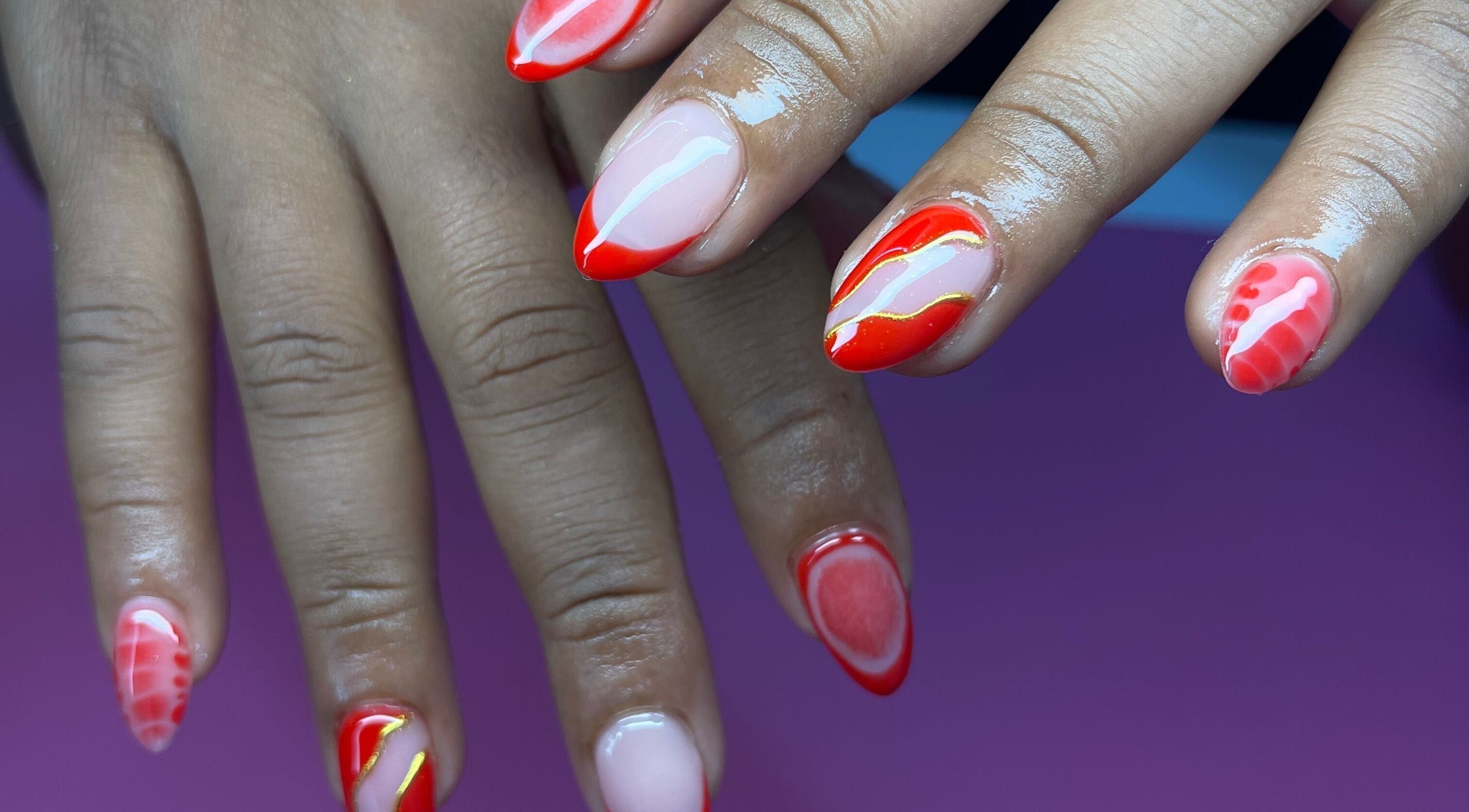 Stylish red nail art at Elegant Tips in Ocho Rios, JM, showcasing creativity and flair.