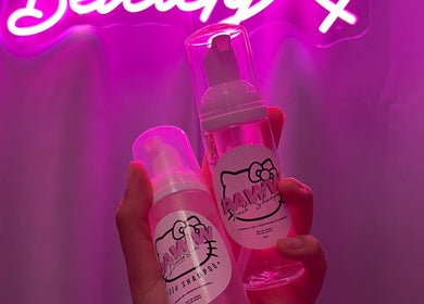 Productos de belleza en Kitty Paw Studio, Barcelona, Catalunya, ES, bajo luces neón rosadas.