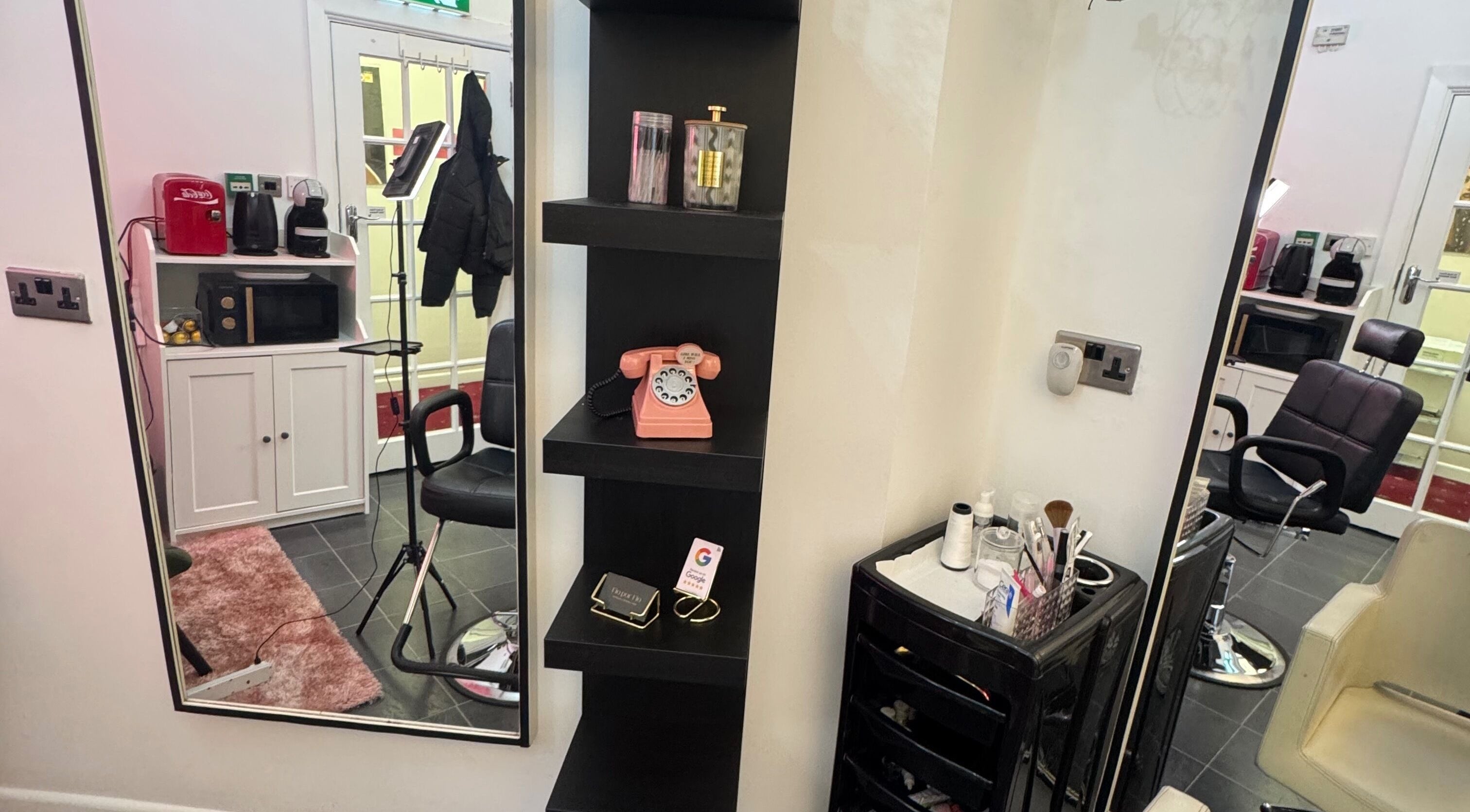 Interior do salão Fio por fio em Dublin, com poltrona, espelho e telefone vintage em prateleira.