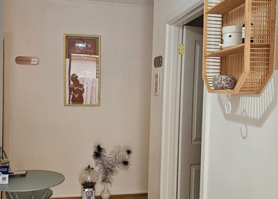 A serene hallway at Joro Studio, Melbourne, Victoria, AU, featuring a small table and decorative peacock feathers.