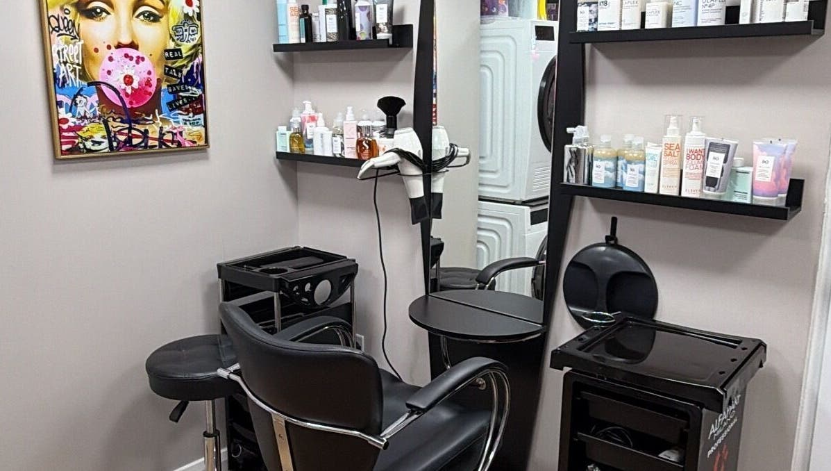 One2one salon in Dublin, County Dublin, IE features a stylish chair, shelves with products, and vibrant wall art.