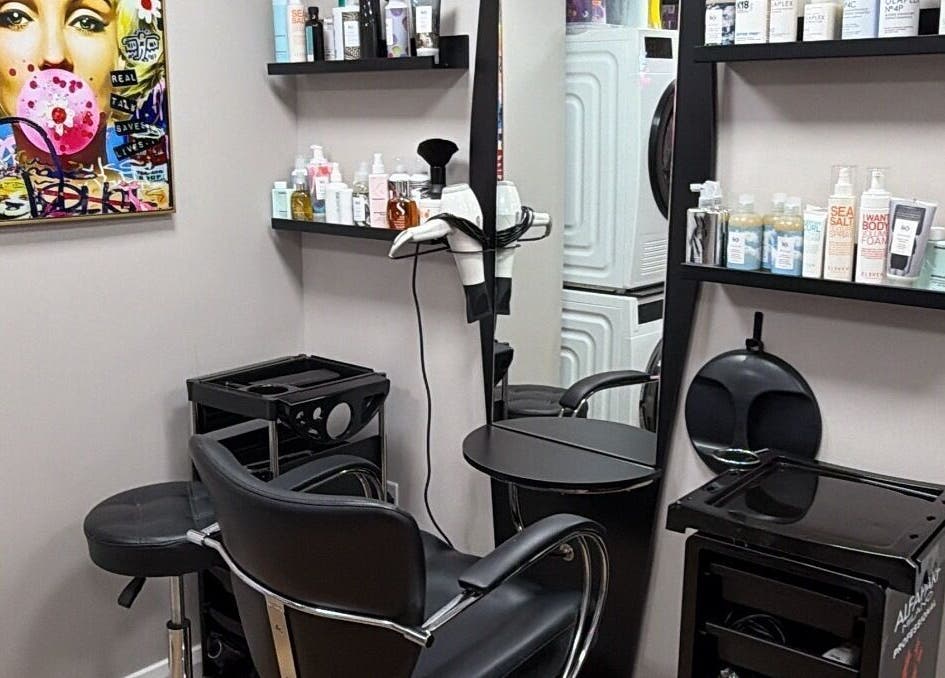 One2one salon in Dublin, County Dublin, IE features a stylish chair, shelves with products, and vibrant wall art.