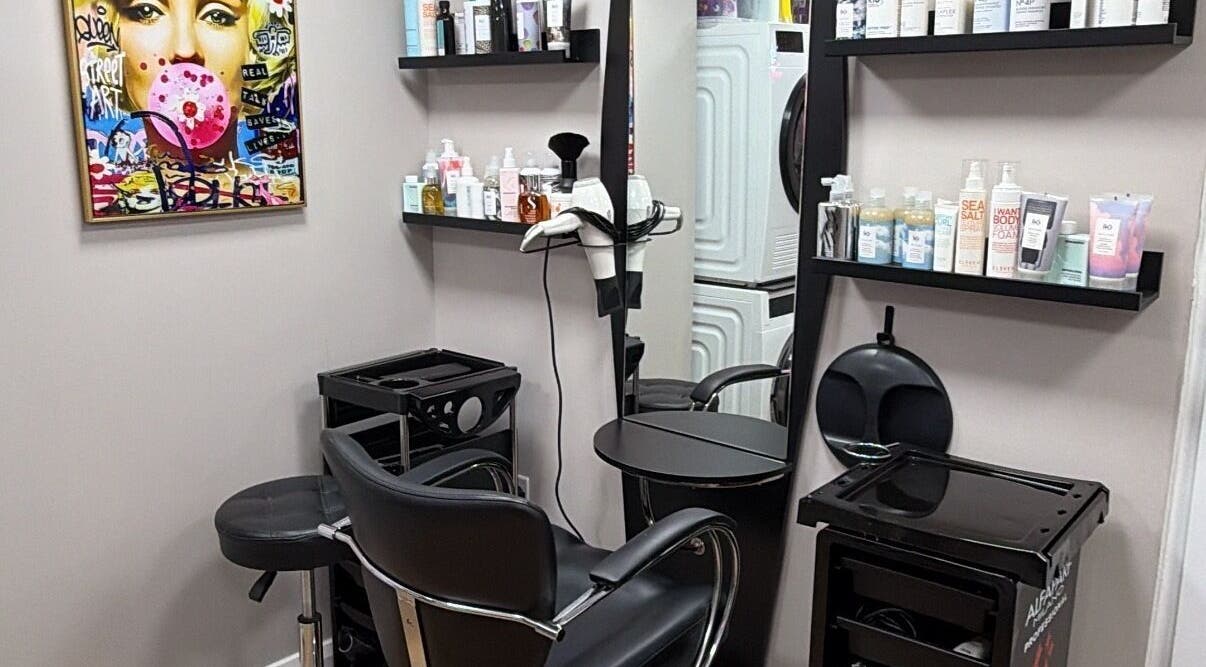 One2one salon in Dublin, County Dublin, IE features a stylish chair, shelves with products, and vibrant wall art.